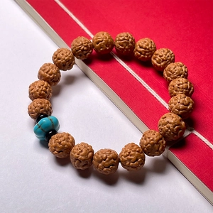 Natural Nepal Rudraksha Bodhi seed bracelet with blue turquoise bead on red background