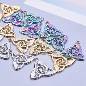 Detailed macro view of 18k gold and silver triquetra celtic witch knot jewelry pendants