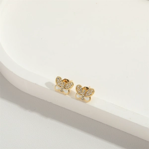 Detailed view of gold butterfly earrings with sparkling crystals and white mother-of-pearl