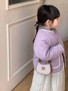 Détail d'une veste matelassée lilas et mini sac à bandoulière pour tenue d'enfant