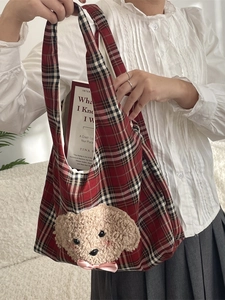 Red plaid tote bag with plush puppy embroidery and pink bow, shown held by a person