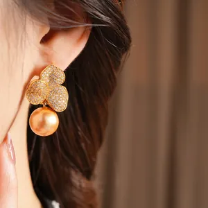 Elegant gold-plated flower earrings with shimmering zircons and hanging golden pearls