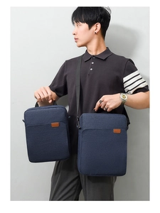 Detail showing deep blue Oxford fabric men's briefcases in two sizes with brown leather logo