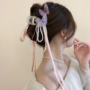 Détail de la pince à cheveux papillon lavande avec longs glands en perles et rubans