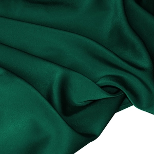 Detailed view of dark green satin fabric texture with elegant silky luster and smooth drape