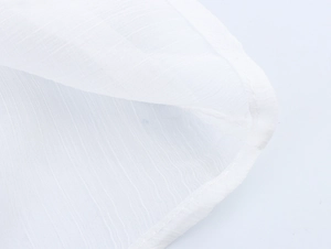 Detailed macro view showing the fine texture and neat stitching of white cotton fabric