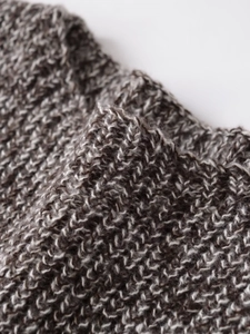 Close-up of thick textured knit fabric detail on a round neck short sleeve top