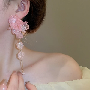 Close-up of pink petal resin tassel earrings with golden links worn by a model