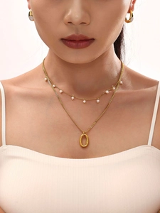 Close-up of model wearing 18K gold plated layered necklace with elegant shell pearls