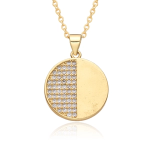 Macro detail of a gold circular pendant with half-pave white zircon and smooth metal finish
