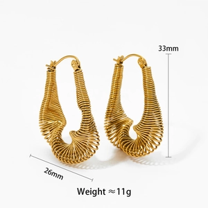 Macro detail of golden twisted C-shaped earrings with 33mm height and 26mm width