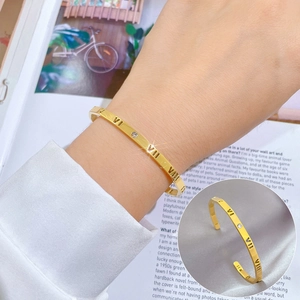 Minimalist gold titanium steel cuff bracelet with Roman numeral engravings and a single crystal