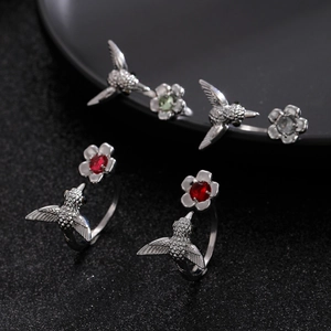 Detailed macro shot of hummingbird ring with intricate engraving and vibrant red gemstone