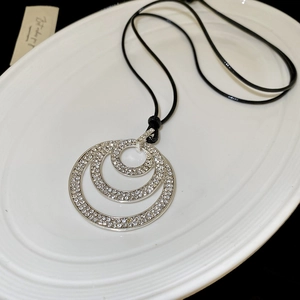 Detailed macro view of triple concentric circles pendant with sparkling crystal inlay