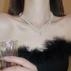 Detail view of double-layer pearl necklace with a sparkling cubic zirconia pendant