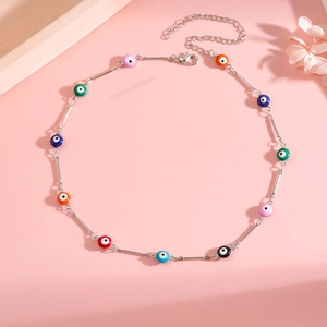 Close-up of a colorful evil eye enamel beaded necklace with silver chain detailing