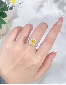 Macro shot of yellow rectangle-cut gemstone ring with beaded double-row silver band