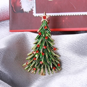 Macro shot of an alloy Christmas tree brooch with colorful enamel on silver velvet fabric