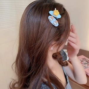 Gros plan de barrettes bleues avec étoile jaune et oursons sur cheveux bouclés