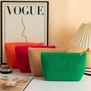 Detailed view of colorful quilted makeup bags in orange, pink, khaki and green