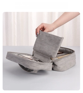 Detail view of large grey makeup bag interior with multiple zippered compartments and slots