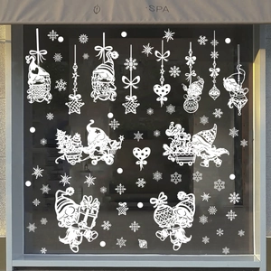 Detail of white Christmas gnome and snowflake static window stickers on a glass store front