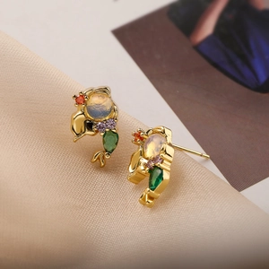 Detailed close-up of gold fish earrings featuring multi-color gemstones and opal accents