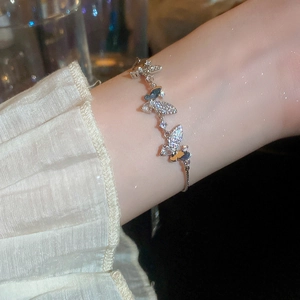 Close-up of a silver butterfly bracelet with sparkling zircon stones on a model's wrist