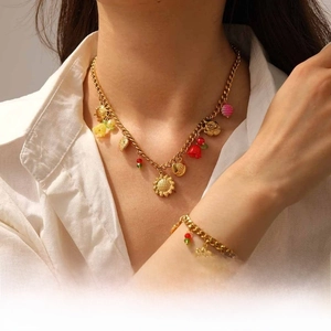 Détail d'une parure dorée avec pendentifs floraux de tournesol et de tulipe