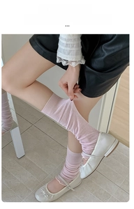 Close-up of pale pink ballet-style ribbed socks showing high elasticity and ruffled edge
