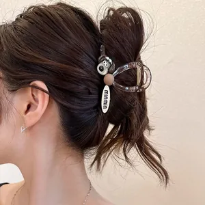 Detail of a brown translucent dog-shaped hair claw clip with a mini tag on hair