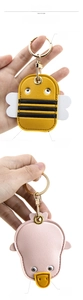 Detail of cartoon bee and duck PU leather keychains with refined stitching and 3D metal eyes
