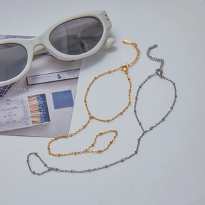 Detailed view of gold and silver stainless steel finger-loop bracelets on white background