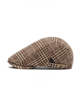 Detail of classic plaid newsboy cap showing brown houndstooth fabric and metal buckle