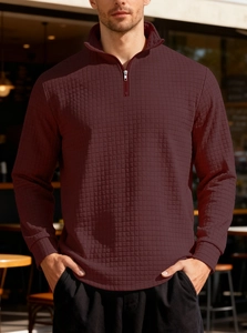 Macro detail of men's burgundy waffle knit texture with a quarter-zip stand collar