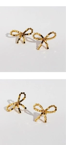 Macro shot of gold bow stud earrings featuring a modern geometric cube design texture
