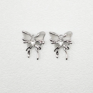 Macro detail of silver butterfly earrings with sparkling crystals and hollow wings