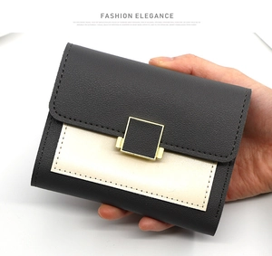 Gros plan du portefeuille femme en cuir litchi noir avec boucle en métal doré