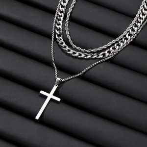 Detail view of silver triple-layer necklace with cross pendant and twisted curb chain link