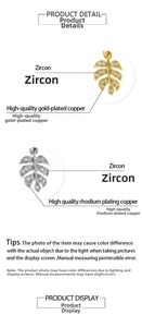 Gros plan détaillé de breloques trèfle plaquées or 18K et rhodium avec pavé de zircons