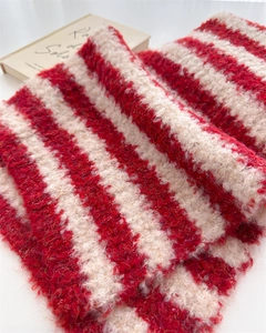 Macro detail of soft red and white striped mohair wool knit scarf with fluffy texture