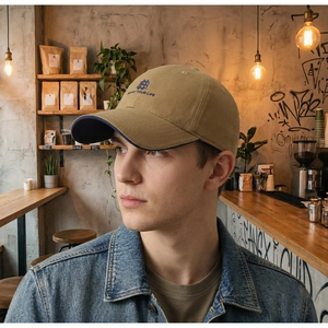 Detail of khaki cotton baseball cap with blue embroidery and vintage contrast brim