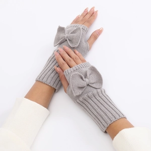 Close-up of gray knit fingerless gloves with bow detail and textured wool finish