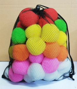Close-up of colorful plush snowball toys in a black mesh bag for Christmas decor