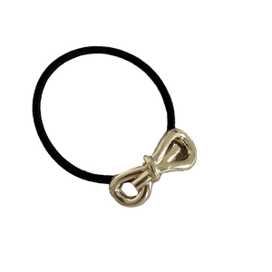 Minimalist golden metal 3D bow hair tie with high elastic black band on white background