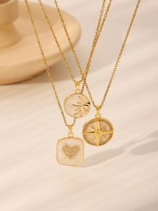 Close-up of three gold necklaces featuring enamel heart, sun, and star compass pendants