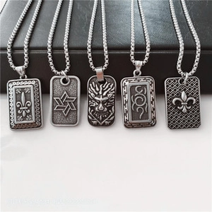 Macro detail of five silver hip-hop square pendants with various engraved motifs and chains