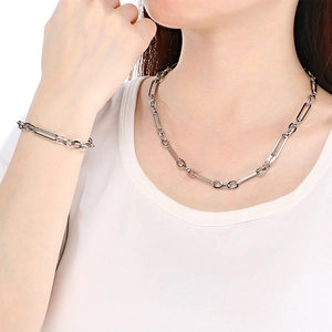 Gros plan d'un collier et d'un bracelet à boucle OT en argent portés par un mannequin