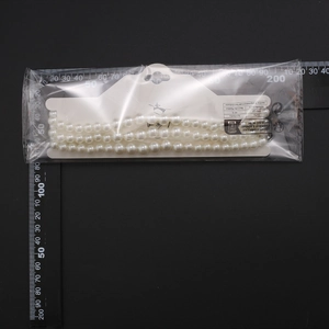 Detailed view of layered multi-strand pearl choker necklace with ruler measurement