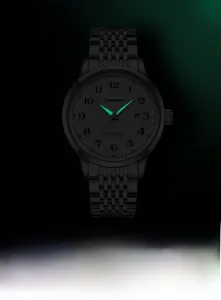 Luminous green hands and markers of the black automatic watch in a dark setting